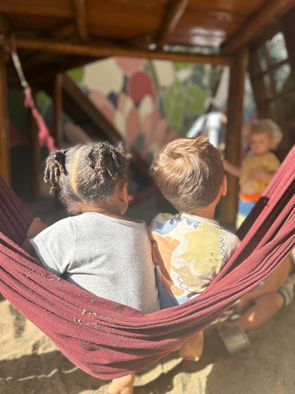 Famílias e crianças reunidas no pátio da escola, celebrando a diversidade da comunidade