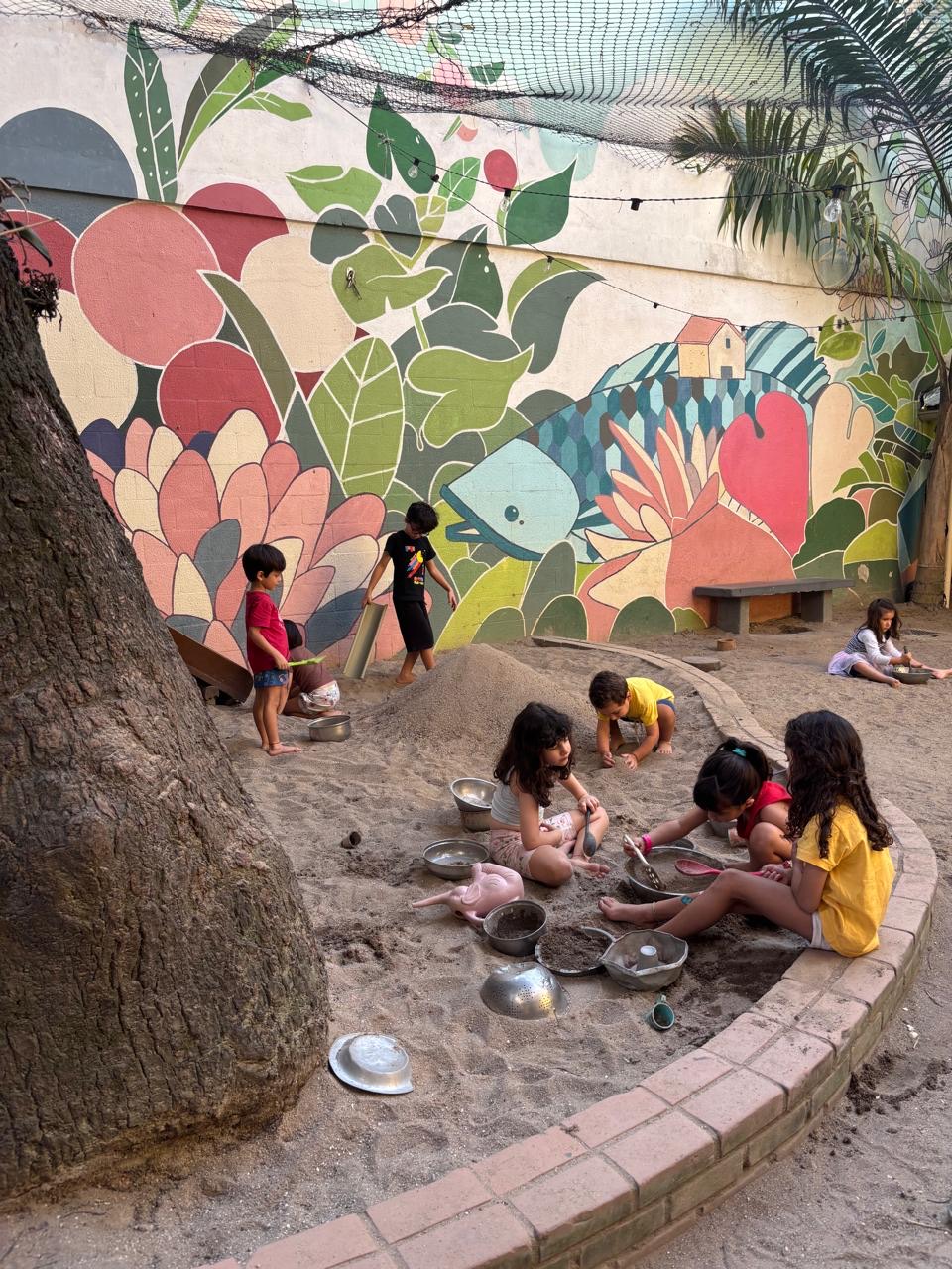 Crianças explorando o quintal da escola entre árvores e terra